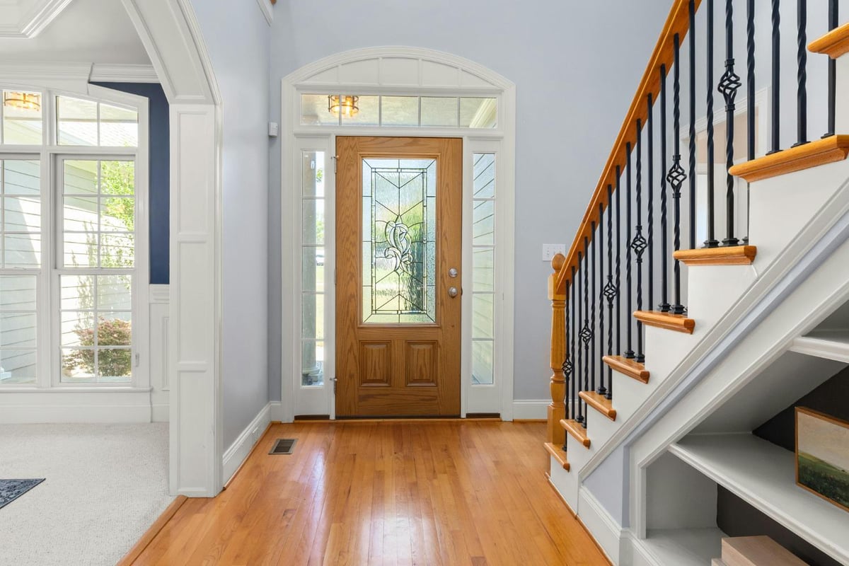 elegant custom home entry with wood door and natural light by Carolina Signature Custom Homes in Troutman, NC