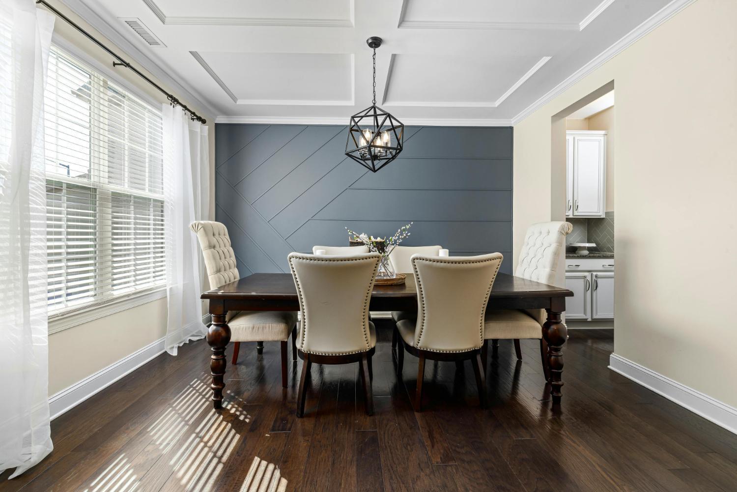 elegant dining space with wood table and decorative wall paneling by Carolina Signature Custom Homes Troutman NC