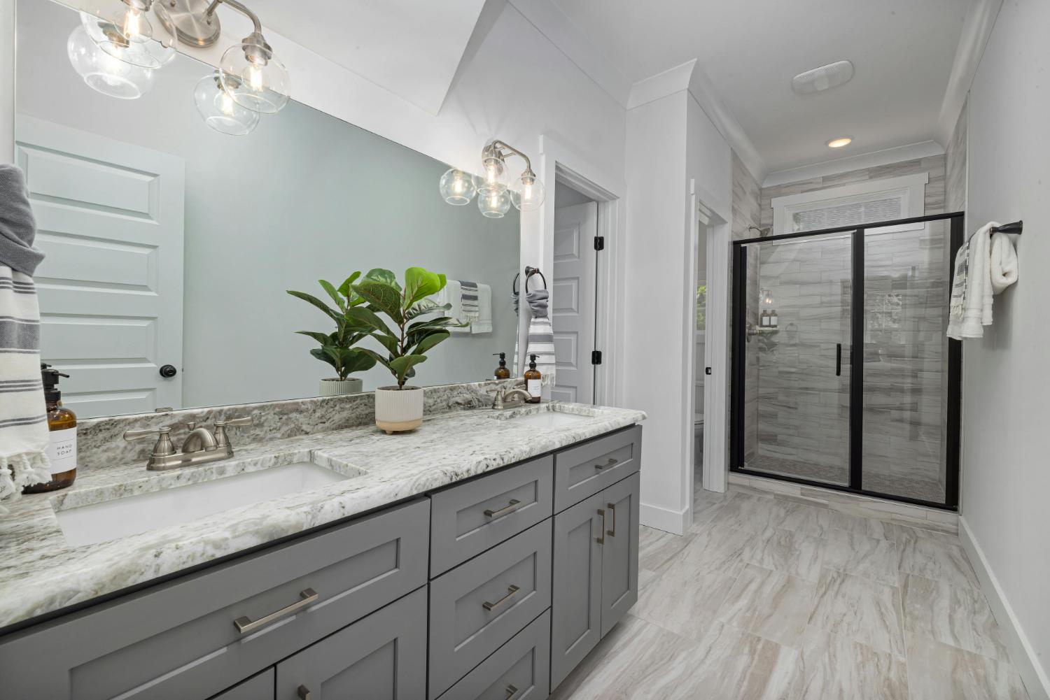 modern double vanity bathroom with granite countertops and glass shower by Carolina Signature Custom Homes in Troutman NC stock-optimized