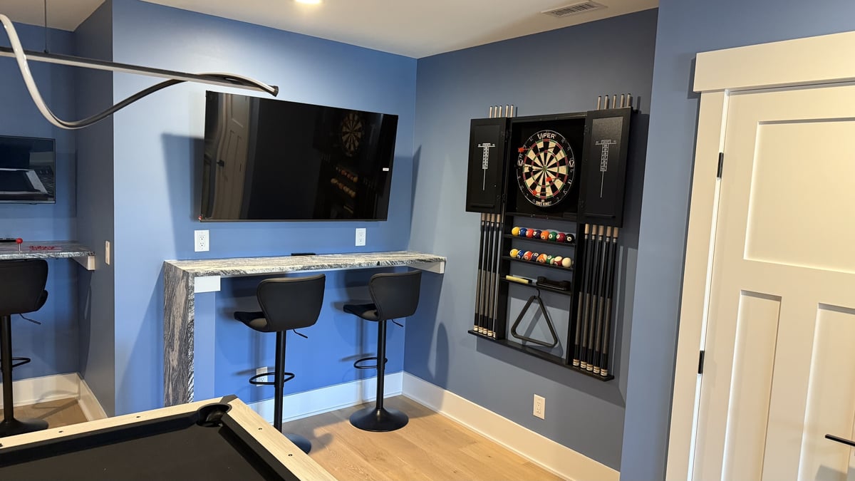 lake norman basement remodel with wall mounted tv dartboard and two counter stools