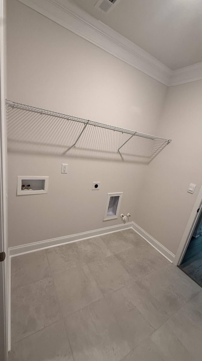 custom laundry installation with tile floor and storage shelf in Troutman, NC by Carolina Signature Custom Homes-optimized