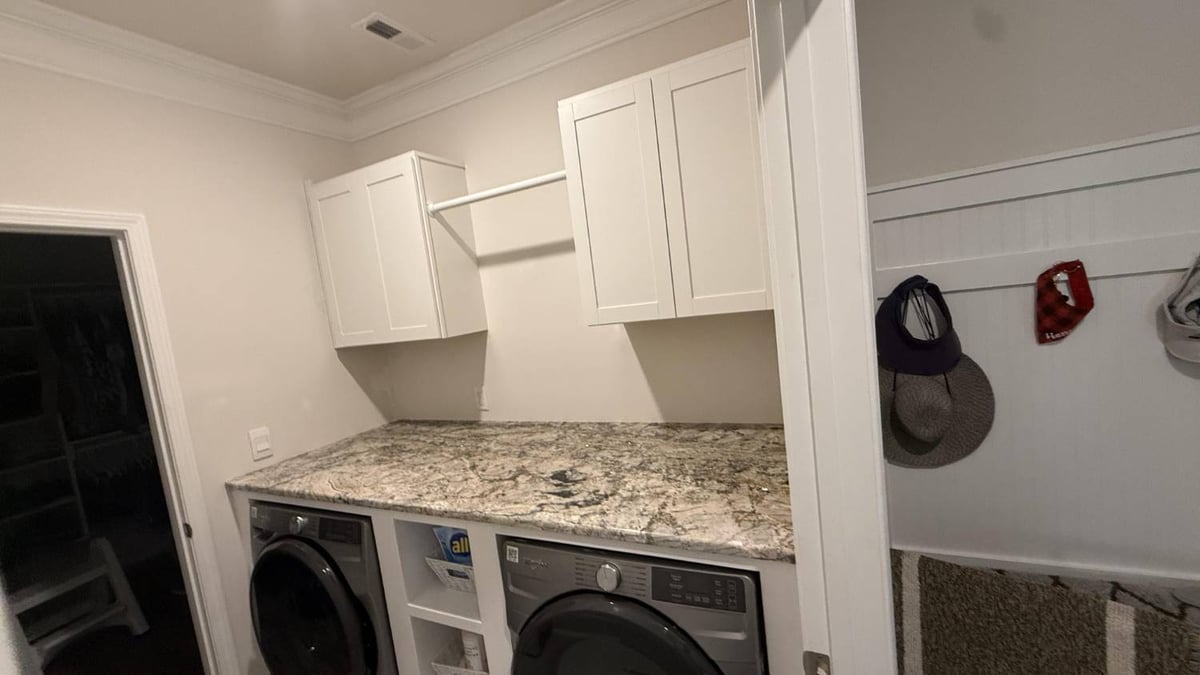 modern laundry space with cabinets and folding counter in Troutman, NC by Carolina Signature Custom Homes-optimized