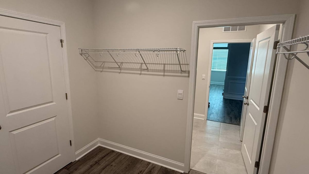 newly built walk-in closet space with wire racks by Carolina Signature Custom Homes in Troutman, NC-optimized