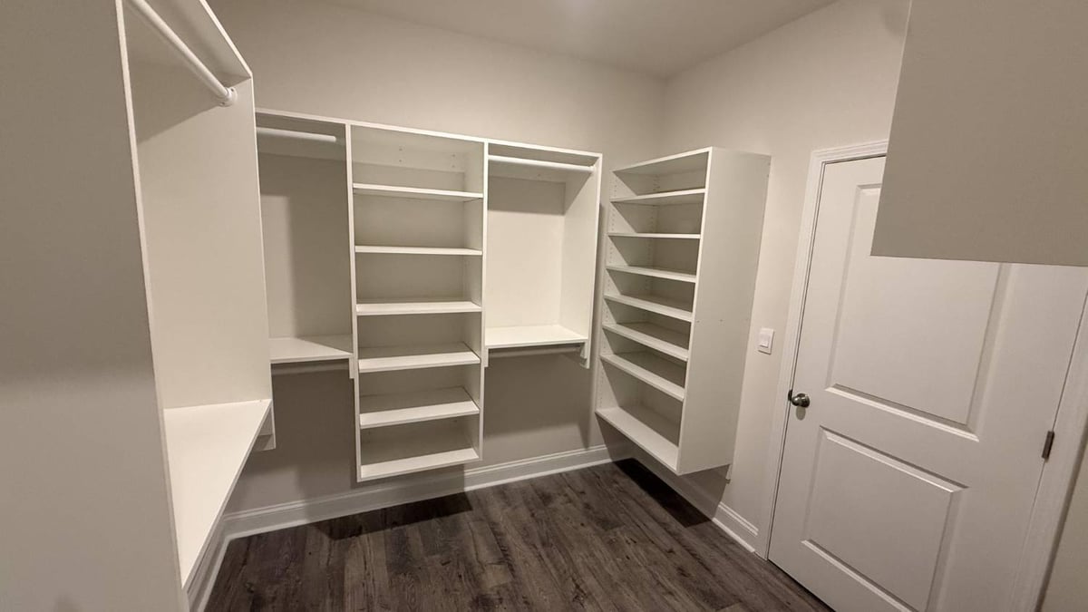 organized walk-in closet with built-in storage system in Troutman, NC by Carolina Signature Custom Homes-optimized