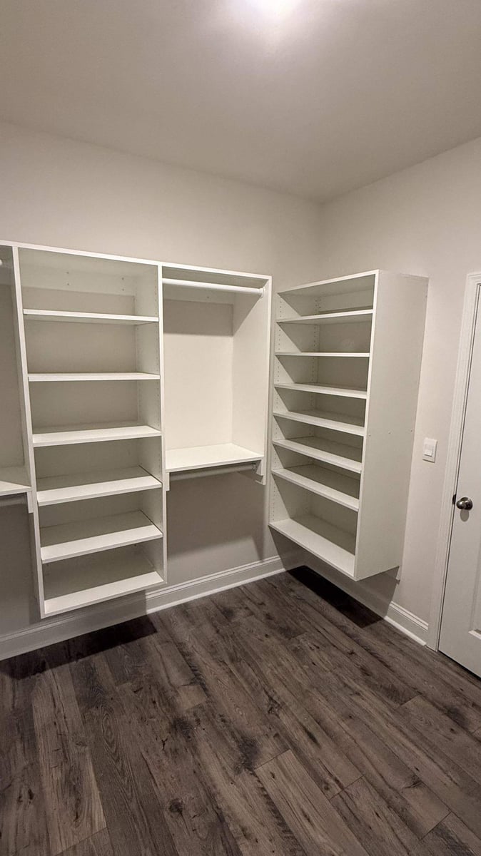 walk-in closet with adjustable shelves and rods in Troutman, NC by Carolina Signature Custom Homes-optimized