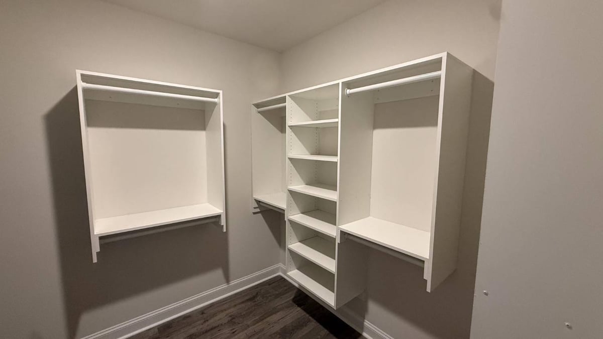 walk-in closet with white built-in storage system in Troutman, NC by Carolina Signature Custom Homes-optimized