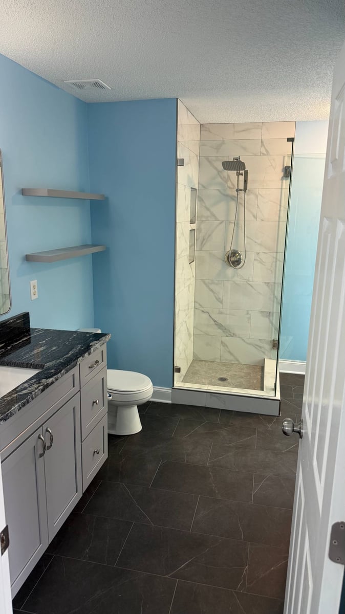 modern bathroom renovation with glass shower and gray tile flooring in Aitken Charlotte NC by Carolina Signature Custom Homes-optimized