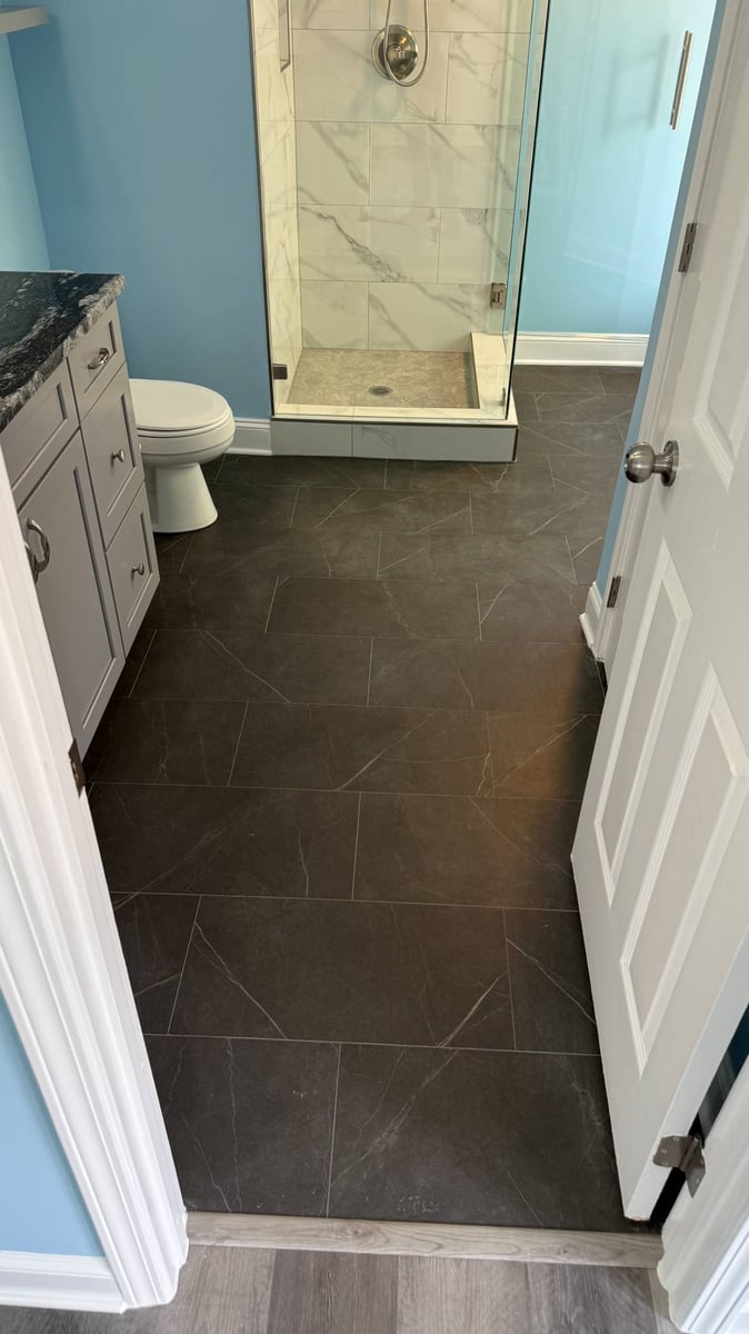 updated bathroom with walk-in shower and dark tile flooring in Aitken Charlotte NC by Carolina Signature Custom Homes-optimized
