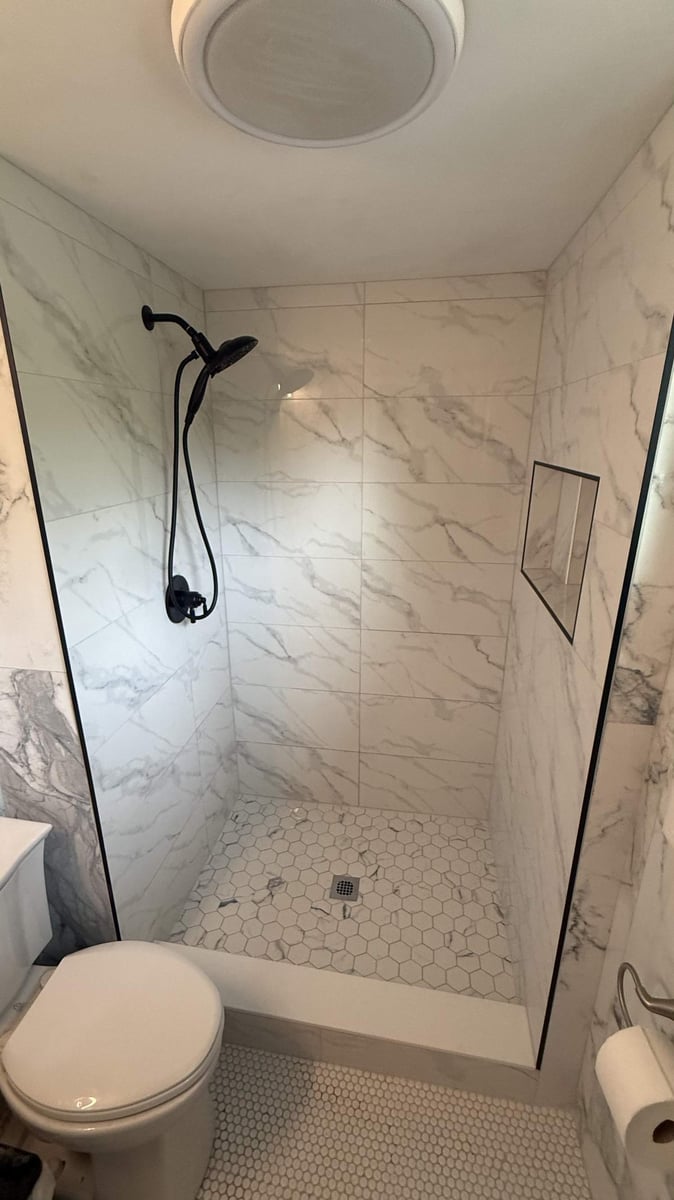 Carolina Signature Custom Homes walk-in shower remodel with marble tile and black showerhead in Lawrence, NC-optimized