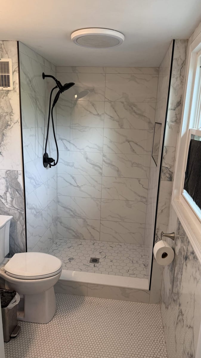 walk-in shower with marble tile surround and hex floor by Carolina Signature Custom Homes in Lawrence, NC-optimized