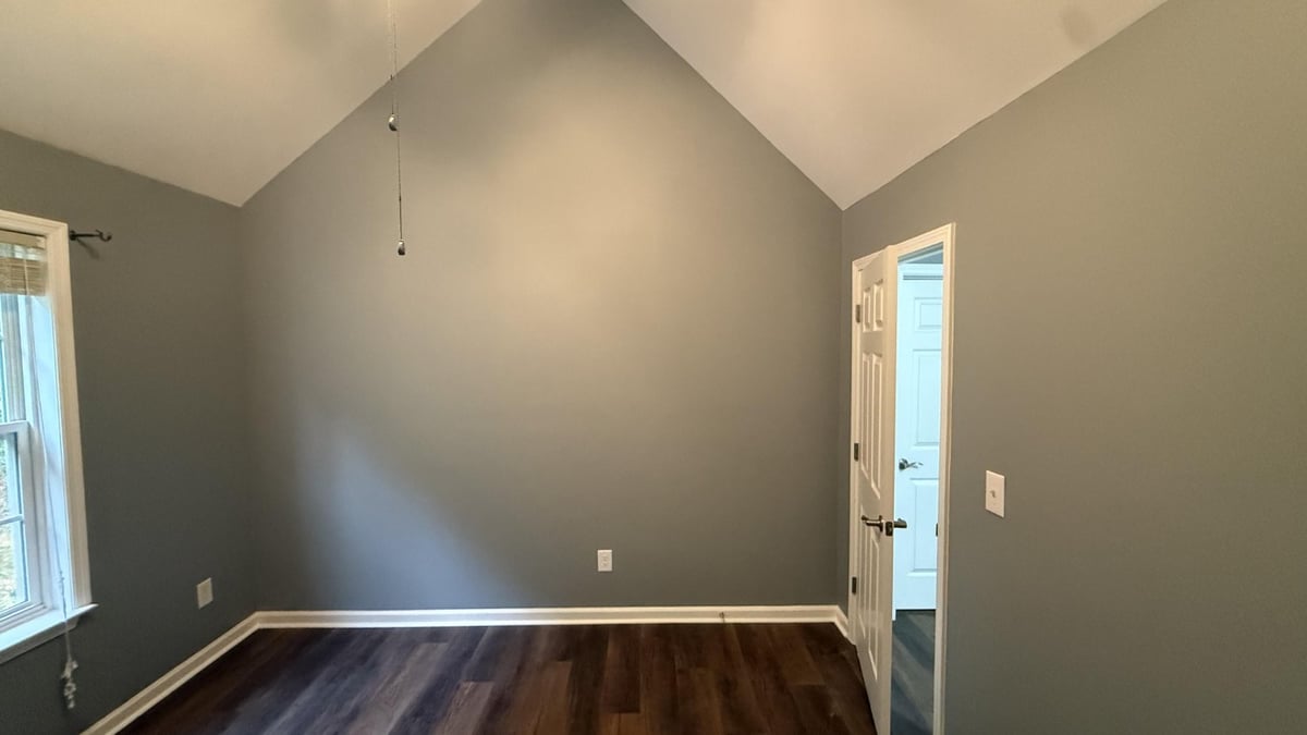 empty bedroom showcasing new wood flooring and gray walls in Mooresville NC by Carolina Signature Custom Homes-optimized