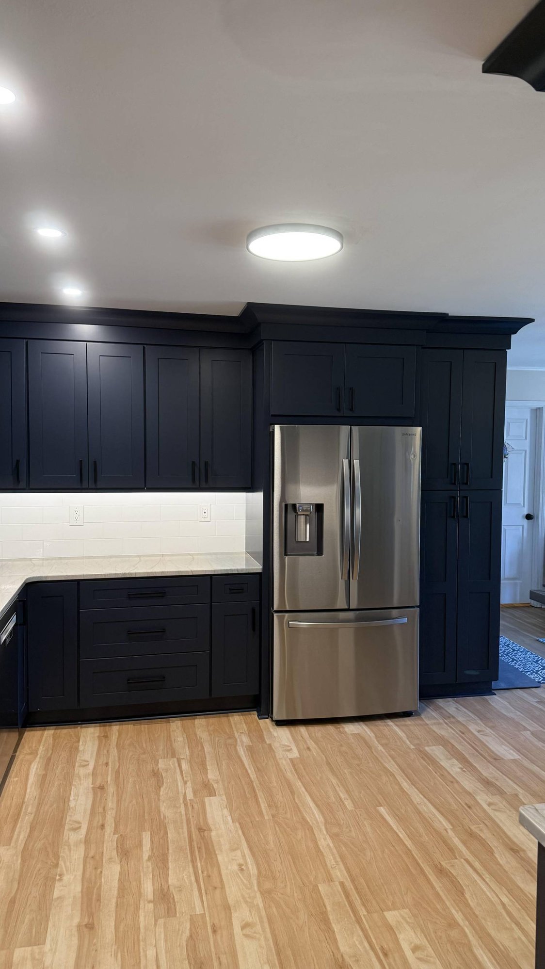 Kitchen remodel in Higgins, NC by Carolina Signature Custom Homes highlighting full-height cabinetry and stainless steel refrigerator