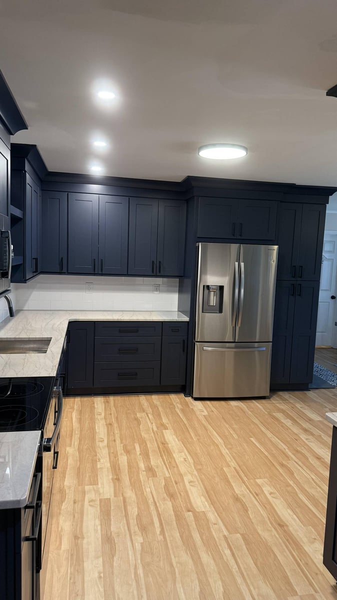 Wide kitchen remodel view in Higgins, NC by Carolina Signature Custom Homes with dark cabinets, quartz countertops, and open flo-optimized