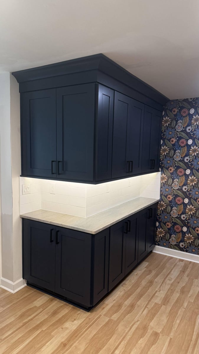 navy blue kitchen cabinetry with tile backsplash in Higgins, NC by Carolina Signature Custom Homes-optimized
