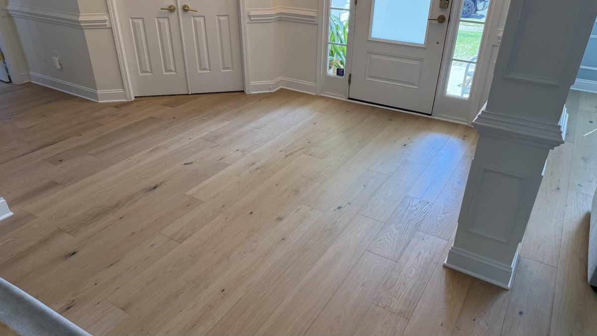Entryway flooring remodel in Hutchinson, NC by Carolina Signature Custom Homes with light wood planks and natural lighting.-optimized