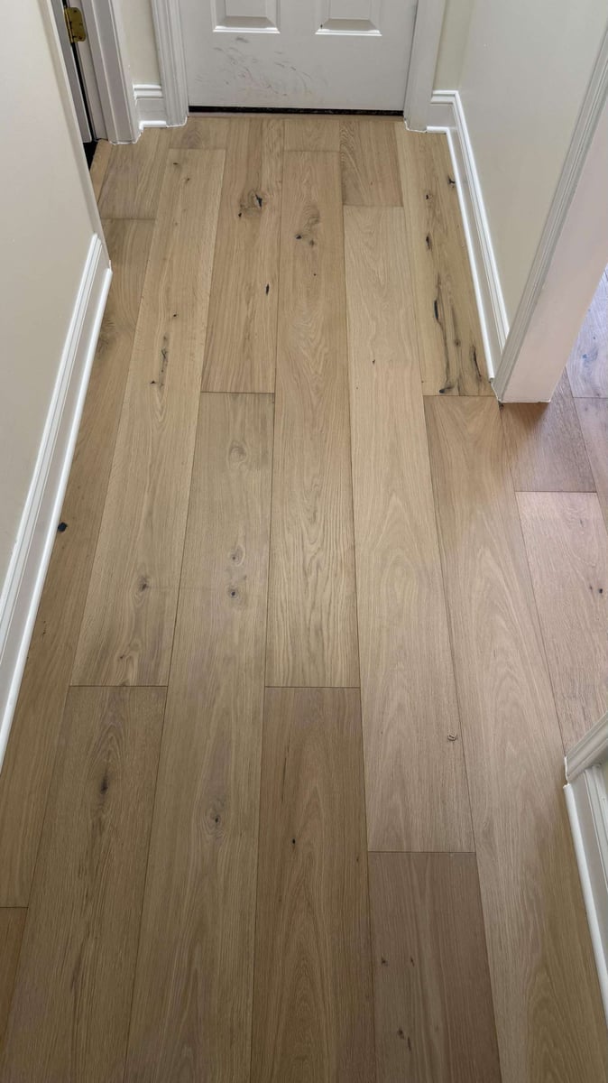 Hallway flooring installation in Hutchinson, NC by Carolina Signature Custom Homes with wide plank hardwood and seamless transit-optimized