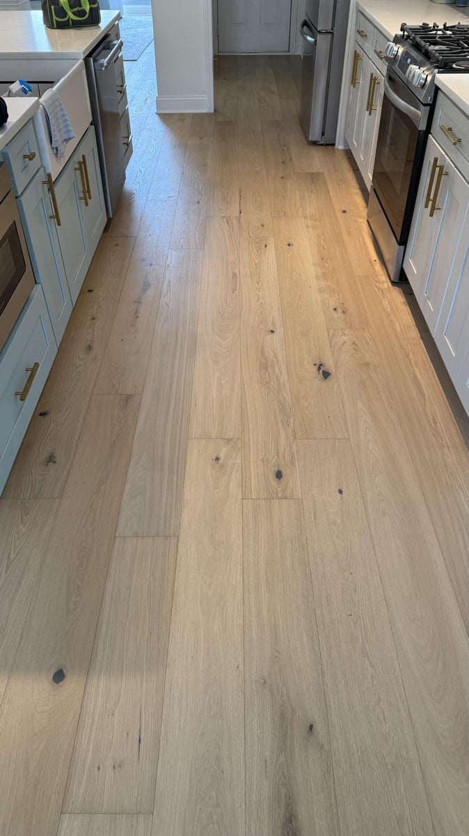 Kitchen flooring remodel in Hutchinson, NC by Carolina Signature Custom Homes with light wood planks and modern cabinetry.-optimized