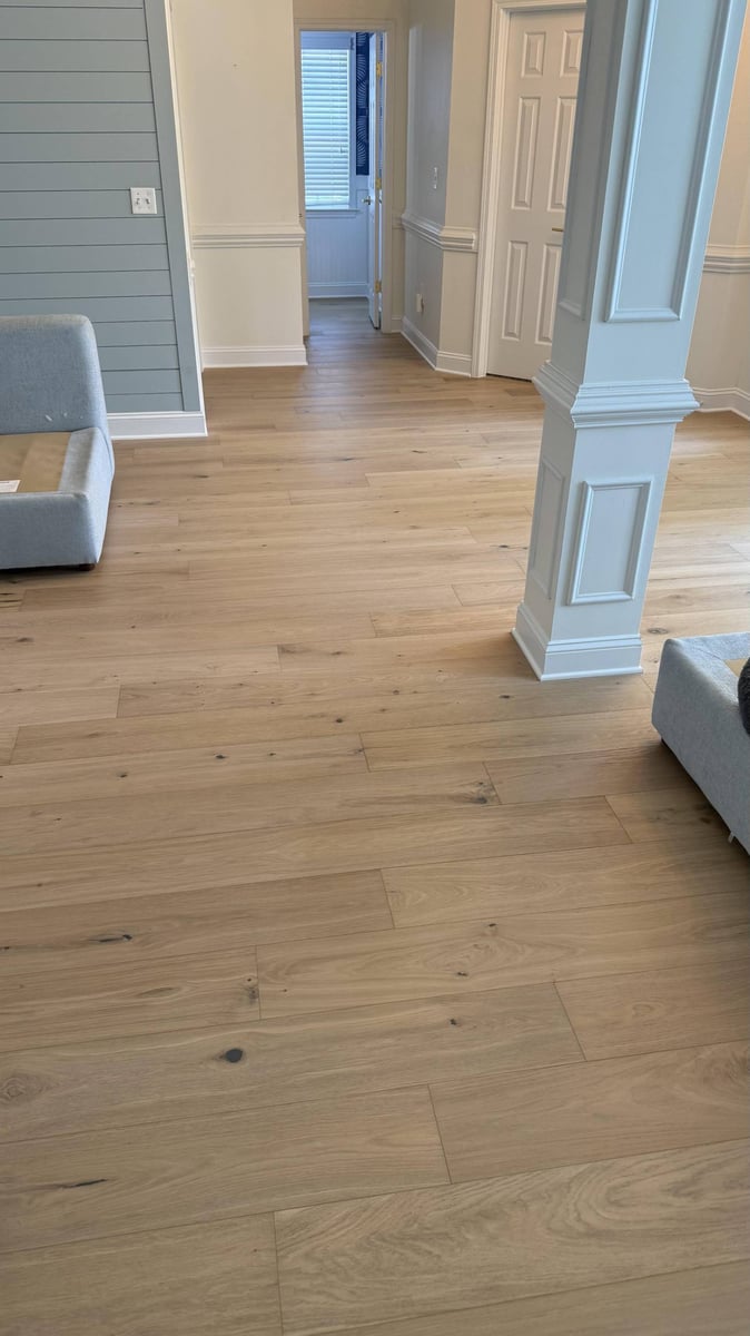 Living room flooring installation in Hutchinson, NC by Carolina Signature Custom Homes with light wood planks and decorative col-optimized