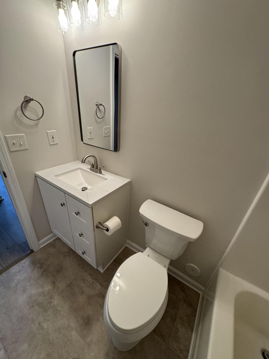 bathroom vanity and toilet area with new flooring, paint, and trim by Carolina Signature Custom Homes in Cornelius, NC-optimized