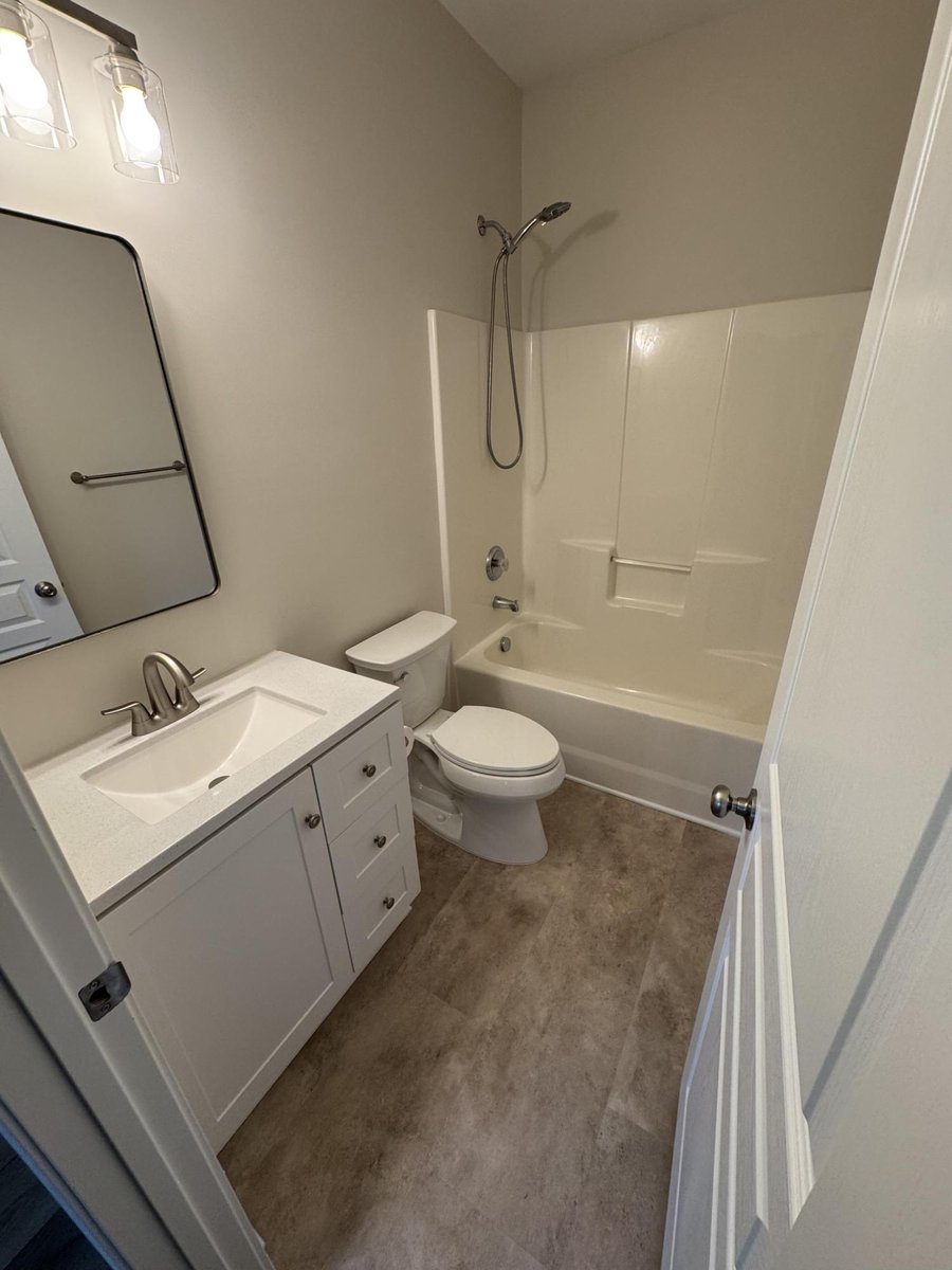 bathroom with vanity, tub, and updated flooring, paint, and trim by Carolina Signature Custom Homes in Cornelius, NC-optimized