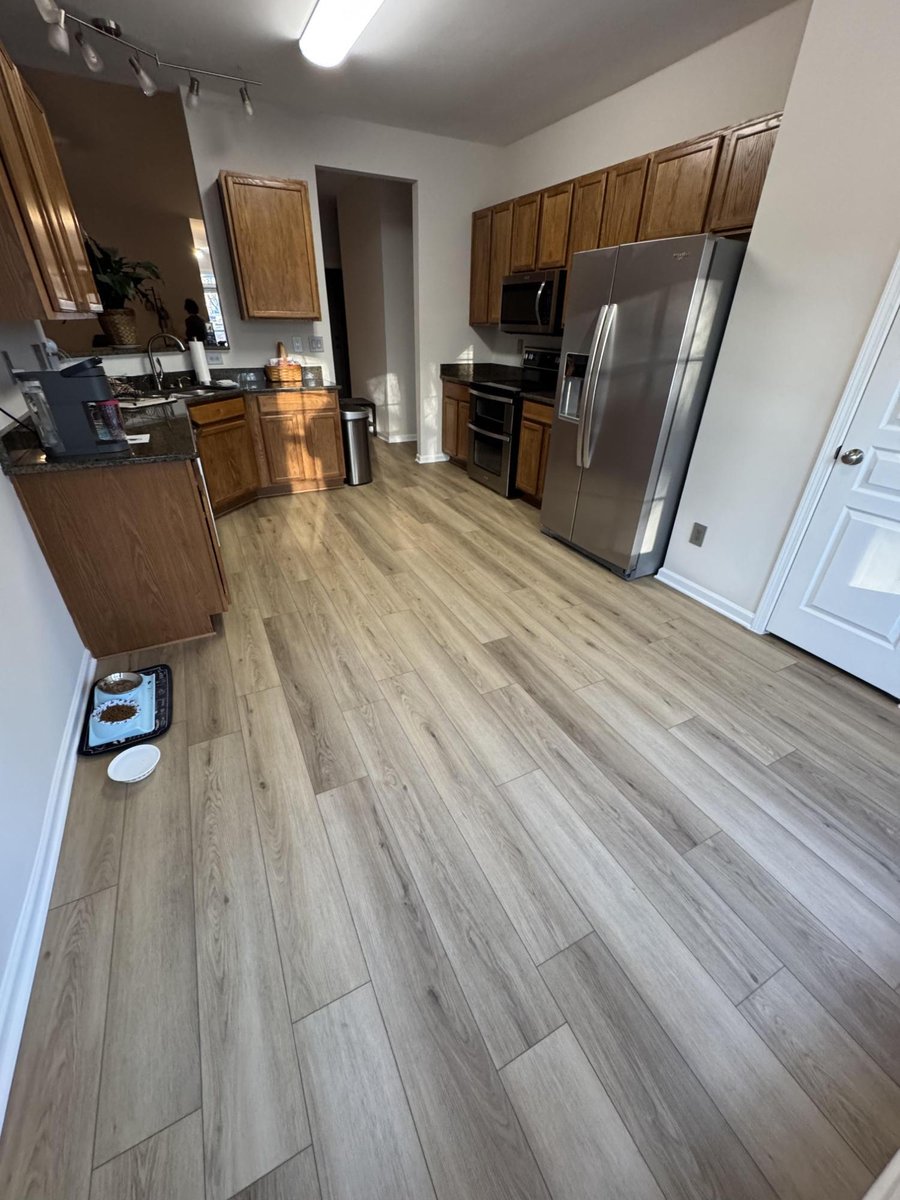 kitchen view with stainless refrigerator and new flooring, paint, and trim by Carolina Signature Custom Homes in Cornelius, NC-optimized