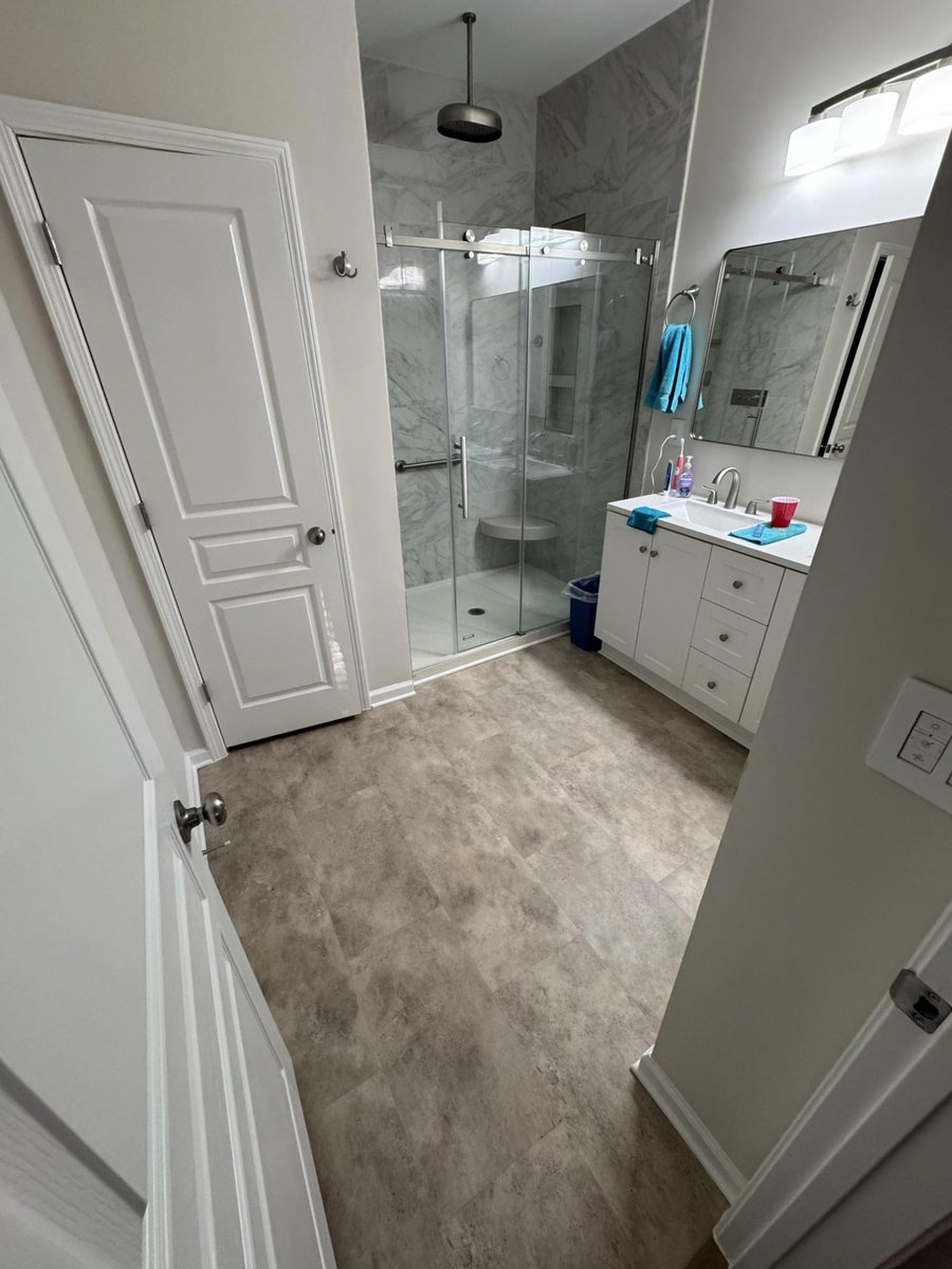 modern bathroom with glass shower and new flooring, paint, and trim by Carolina Signature Custom Homes in Cornelius, NC-optimized