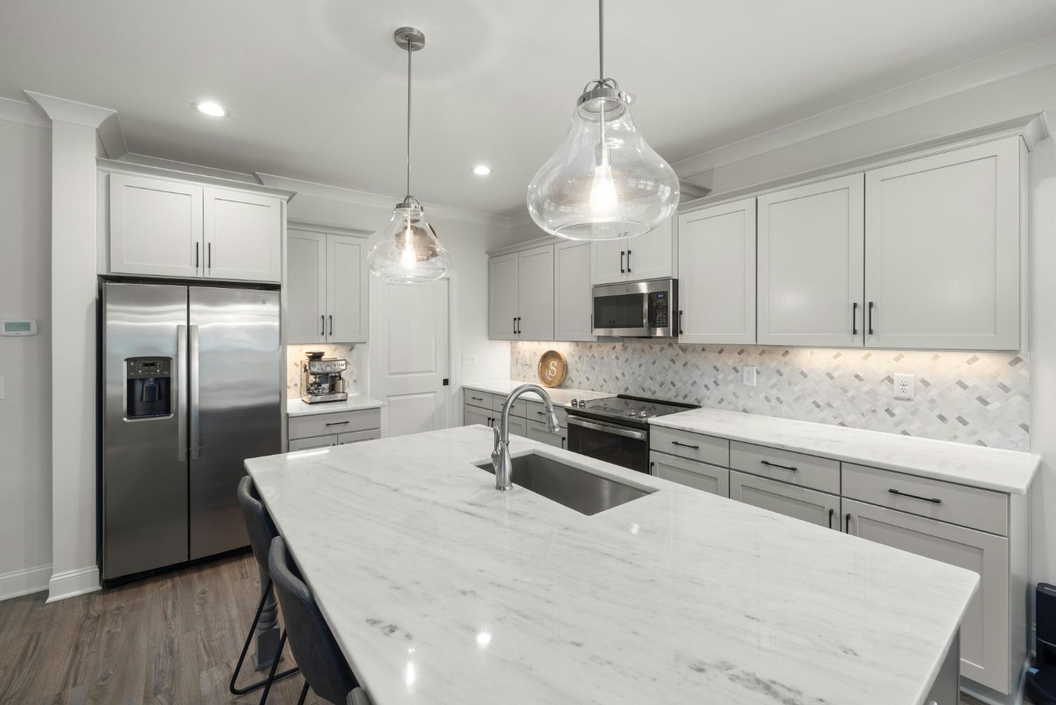 contemporary kitchen with large island and backsplash detail in Troutman, NC by Carolina Signature Custom Homes stock-optimized