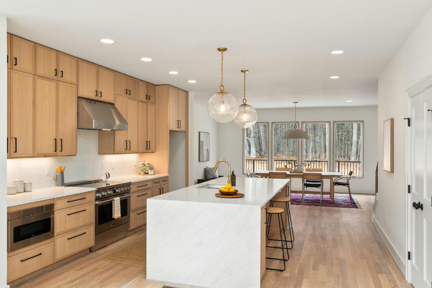modern white kitchen with large island and pendant lighting in Troutman NC custom home by Carolina Signature Custom Homes stock-optimized
