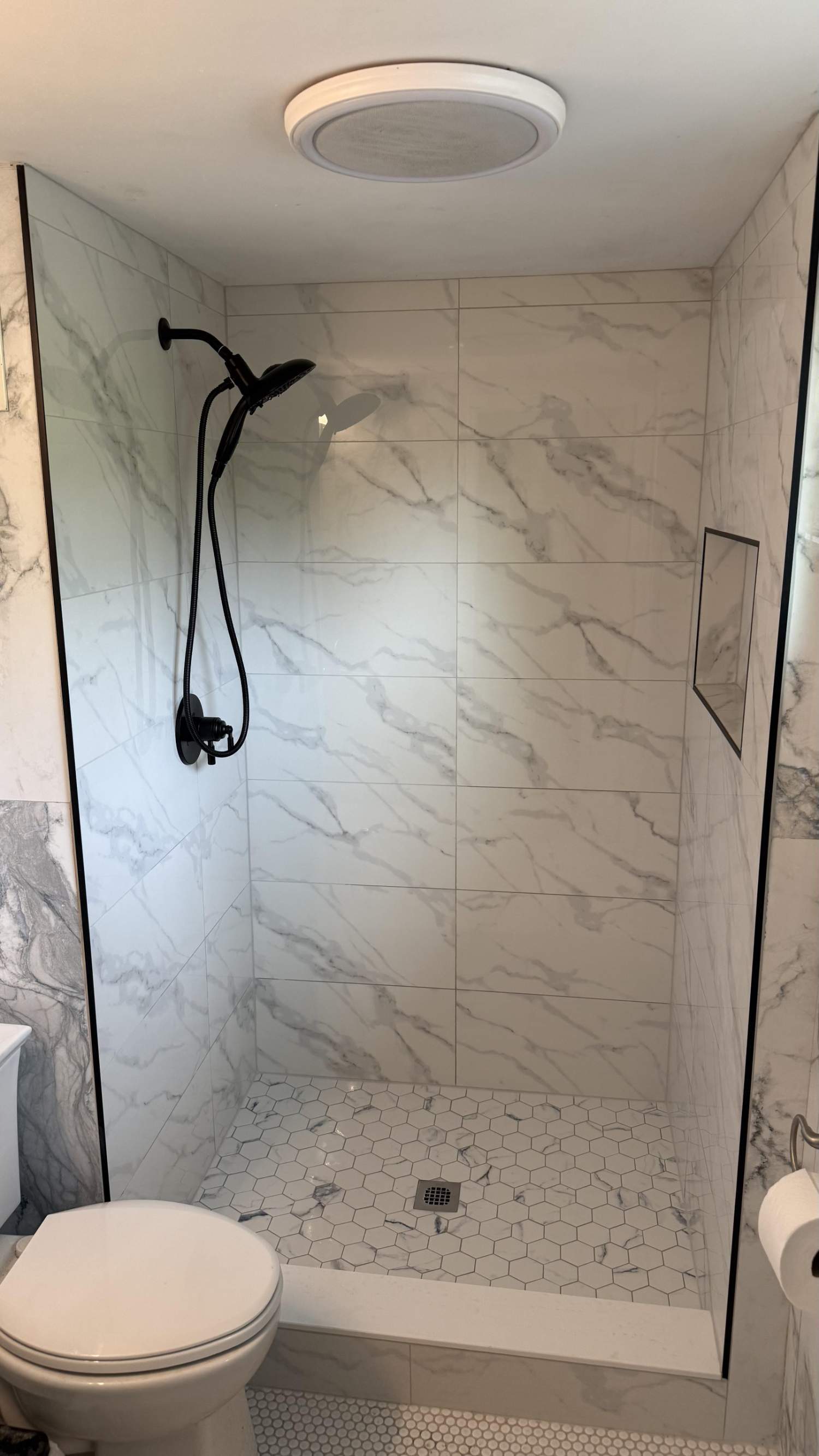 walk-in shower renovation with marble-look tile and niche by Carolina Signature Custom Homes in Lawrence, NC-optimized